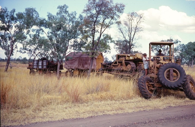The author and driver astride road building equipment in the Australian Outback.